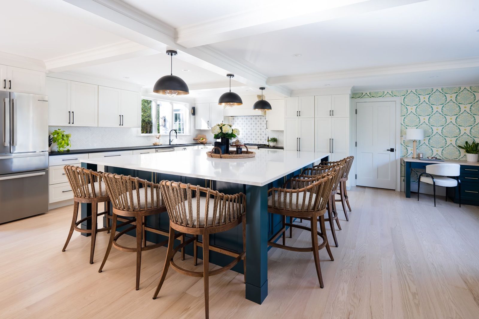 Jerusalem Road kitchen with large rich blue-green island, woven bar stools, white shaker cabinetry, and patterned tile backsplash